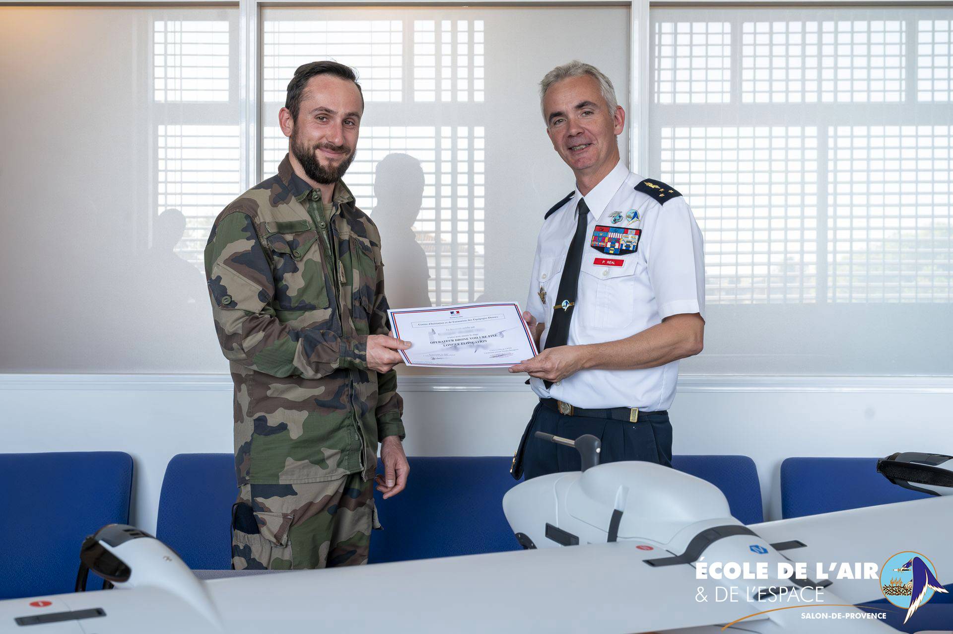 Le général Réal, commandant l'École de l'air et de l'espace et la Base aérienne 701, remettant un certificat de formation à un opérateur drone.